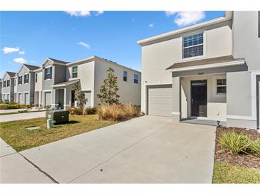 Two-story townhome with attached garage and landscaped front yard at 33055 Tulip Petal Ln, Wesley Chapel, FL 33545