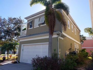 Tan two-story house with white garage door and palm trees at 6519 Simone Shores Cir, Apollo Beach, FL 33572