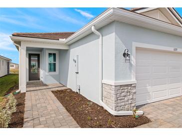 House exterior featuring a light blue facade, white garage door, and a paved walkway at 11277 Boundless Ter, Venice, FL 34293