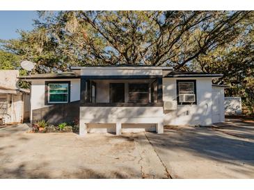 Charming bungalow with covered porch and mature landscaping at 519 Greenway Dr, Plant City, FL 33566