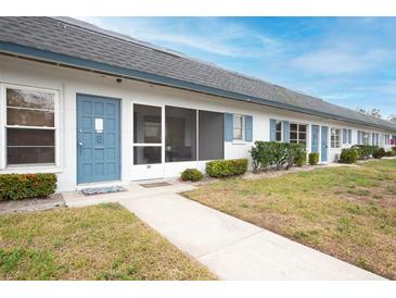 Front view of a condo building showcasing a well-maintained lawn and building exterior at 4444 Swift Rd # 20, Sarasota, FL 34231