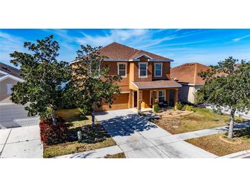 Two-story house with a brown exterior, driveway, and landscaping at 708 Fern Leaf Dr, Ruskin, FL 33570