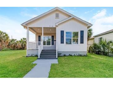 Charming single-story home with a well-maintained lawn, inviting porch, and blue shuttered windows at 719 19Th S St, St Petersburg, FL 33712