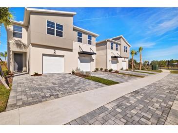 Three-unit townhome building with attached garages and paved driveways at 5639 Brooklet Woods Dr, Wesley Chapel, FL 33545