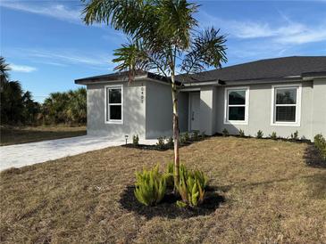 New gray house with a paved driveway and landscaping at 10334 Pendleton Ave, Englewood, FL 34224