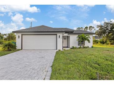 New construction home with a two-car garage and landscaped lawn at 12114 Clarendon Ave, Port Charlotte, FL 33981