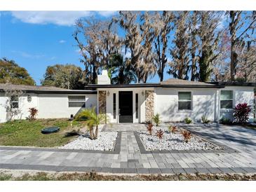 Charming single-story home with stone accents, manicured landscaping, and a welcoming entrance at 5028 School Rd, Land O Lakes, FL 34638