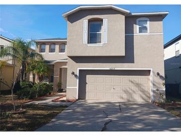 Two-story house with a neutral color exterior, two-car garage, and landscaping at 10319 Boyette Creek Blvd, Riverview, FL 33569