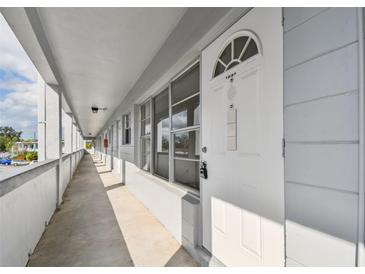 White building exterior with walkway and individual apartment entrances at 4300 58Th N St # 1907, Kenneth City, FL 33709