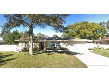 Tan single story home with attached garage and a spacious yard at 1948 Jeffords St, Clearwater, FL 33764
