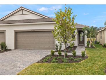 New construction home exterior with two-car garage and landscaped yard at 20375 Symphony Pl, Venice, FL 34293