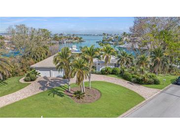 Aerial view of waterfront home with circular driveway and lush landscaping at 411 Belle Isle Ave, Belleair Beach, FL 33786