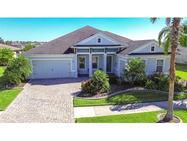 Beautiful two-story house with gray roof, light blue exterior, and a paver driveway at 11521 Lake Lucaya Dr, Riverview, FL 33579
