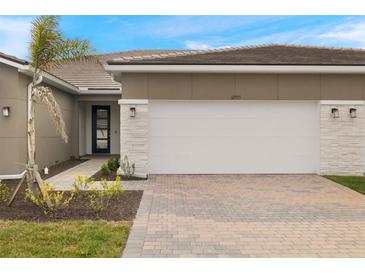 Modern home exterior with two-car garage and landscaped walkway at 12355 Hearts Ease St, Venice, FL 34293