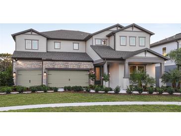 Two-story home with stone accents and a three-car garage at 13813 Sharp Hawk Dr, Riverview, FL 33569