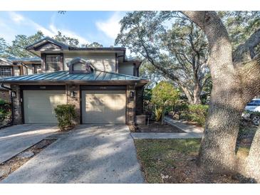 Two-car garage, front yard landscaping, and brick facade at 1510 Mahogany Ln # 606, Palm Harbor, FL 34683