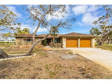 House exterior with double garage and mature landscaping at 945 Bayshore Dr, Tarpon Springs, FL 34689
