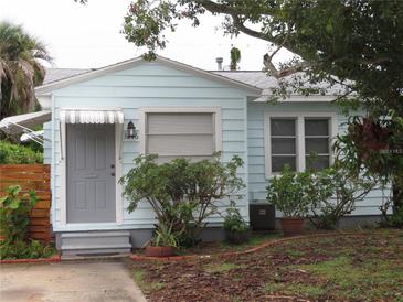 Charming light blue house with gray door, landscaping, and a walkway at 3246 Prescott N St, St Petersburg, FL 33713