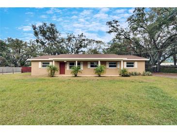 Brick ranch home with a large front yard and mature trees at 1406 E Spencer St, Plant City, FL 33563