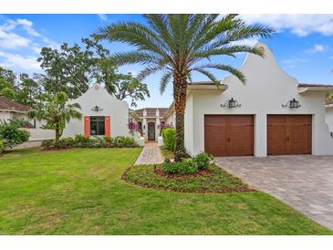 Stunning curb appeal featuring a two-car garage and lush landscaping at 16920 Villalagos De Avila, Lutz, FL 33548