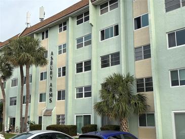 Asbury Arms exterior view, showing a multi-story building with palm trees and parked cars at 801 83Rd N Ave # 511, St Petersburg, FL 33702