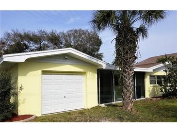 Ranch style home with attached garage and palm tree in front yard at 105 Causeway Blvd, Belleair Beach, FL 33786