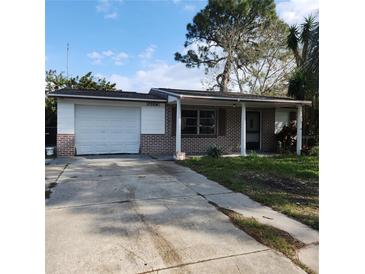 Brick house with a single car garage and a small front yard at 7304 Dianne Dr, New Port Richey, FL 34652