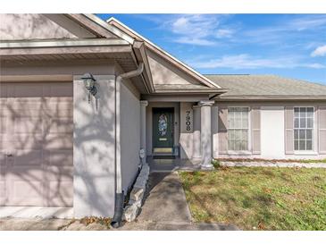 Charming home featuring a decorative front door, light gray paint, and manicured lawn at 7908 E White Water Ct, Tampa, FL 33637