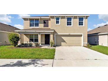 Two-story house with a two-car garage and a well-manicured lawn at 16743 Carlton Pond St, Wimauma, FL 33598