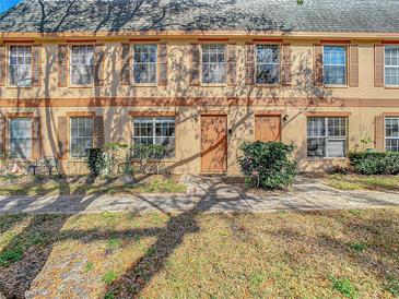 Tan two-story townhome with shutters, a walkway, and landscaping at 4405 Vieux Carre Cir # 46, Tampa, FL 33613