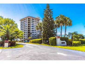 Luxury beachfront condo building with lush landscaping and gated entrance at 736 Island Way # 606, Clearwater Beach, FL 33767
