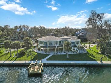 Waterfront home with circular design, private dock, and lush landscaping at 6119 Gnarled Oak Ln, Englewood, FL 34223
