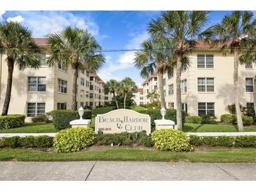 Beach Harbor Club condo building, featuring a welcoming entryway and landscaping at 3806 Gulf Of Mexico Dr # C211, Longboat Key, FL 34228