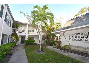 Exterior view of condo building with lush landscaping and walkways at 4315 Aegean Dr # 110C, Tampa, FL 33611