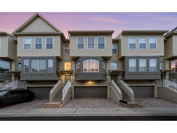 Three-story townhouses with attached garages and stairs at 4338 Spinnaker Cove Ln, Tampa, FL 33615