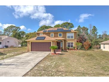 Two story home features an attached garage and solar panels at 2359 Gimlet Ave, Spring Hill, FL 34608