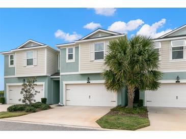 Two-story townhouses with attached garages and landscaping at 1003 Starboard Ct, Oldsmar, FL 34677