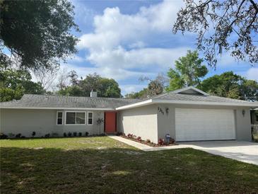 Newly renovated single-story home with gray exterior, orange door and a two-car garage at 1311 4Th W St, Palmetto, FL 34221
