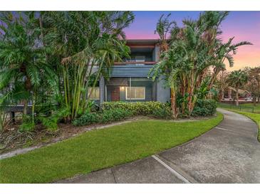 Condo building with lush landscaping and a paved walkway at 10263 Gandy N Blvd # 107, St Petersburg, FL 33702