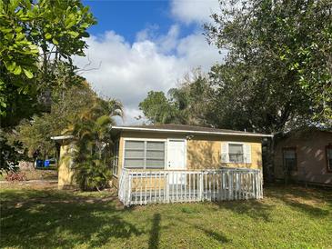 Cute yellow house with a small deck and a yard at 450 47Th S St, St Petersburg, FL 33711