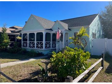 Charming light teal home with a screened porch, white picket fence, and landscaped yard at 2828 Burlington N Ave, St Petersburg, FL 33713