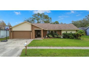 House exterior with a two-car garage and well-maintained lawn at 1307 Windjammer Pl, Valrico, FL 33594