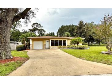 Ranch style home with a large yard and driveway at 10908 W Elbow Dr, Tampa, FL 33612