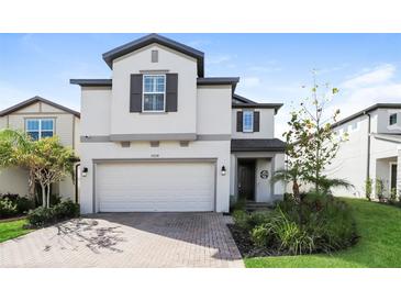 Two-story home with gray exterior, two-car garage, and landscaped lawn at 19238 Old Spanish Rd, Tampa, FL 33647