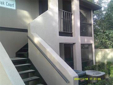 Exterior view of condo building with stairs and screened balcony at 4036 Angel Oak Ct # 101, Tampa, FL 33613
