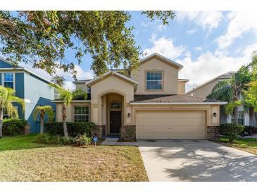 Two-story house with tan exterior, landscaping, and a two-car garage at 529 Vista Ridge Dr, Ruskin, FL 33570