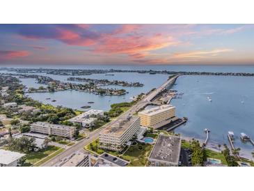 Aerial view of waterfront property showing building, bridge, and boats at 100 Bluff View Dr # 602A, Belleair Bluffs, FL 33770