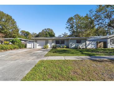 Ranch style home with a green exterior, driveway, and nicely landscaped lawn at 1829 West Dr, Clearwater, FL 33755