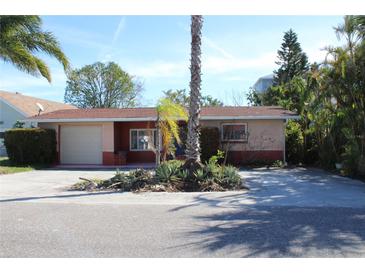 Single-story home with a spacious yard and palm trees at 215 176Th Terrace E Dr, Redington Shores, FL 33708