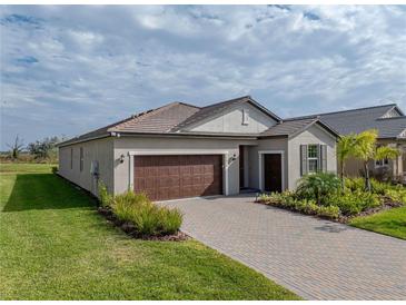 Attractive single-story home with a brown garage door and landscaped front yard at 12626 Tahitian Pearl Cir, Parrish, FL 34219